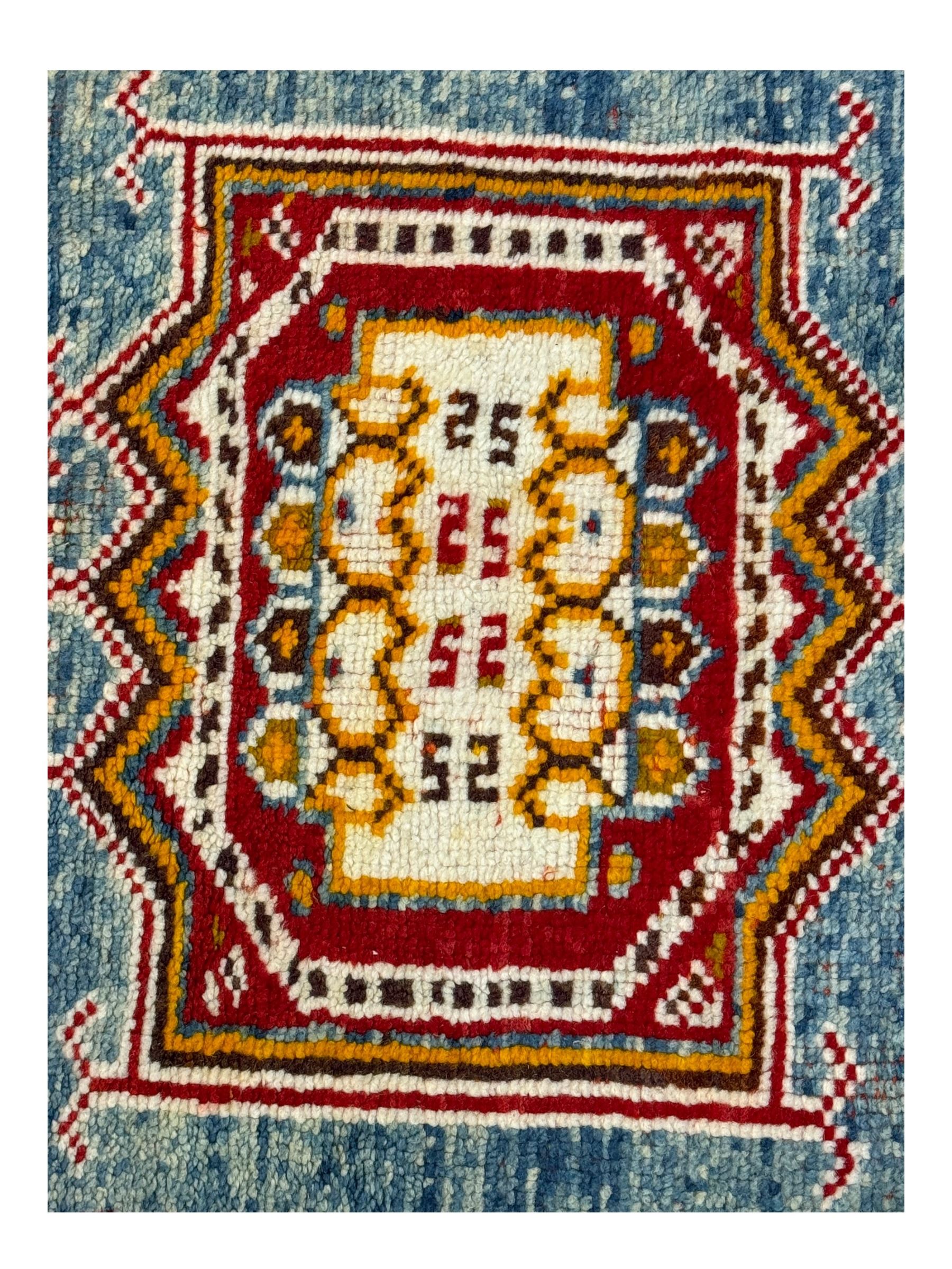 Persian Qashqai crimson ground rug, the field with central indigo and yellow medallion with geometric motifs, flanked by smaller medallions, border with repeating patterns (112cm x 200cm); Turkish Kazak light blue ground rug (109cm x 193cm); red ground runner with three octagonal medallions (69cm x 138cm)