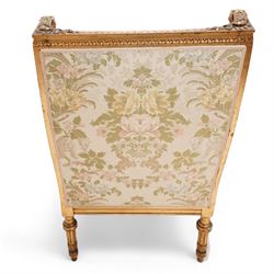 Late 19th century French gilt wood and gesso enclosed armchair, the cresting carved with floral bouquets over foliate moulding, upholstered in floral pattern fabric with repeating pattern, down-swept arms with scrolled acanthus leaf terminals, on turned and fluted feet carved with foliage 