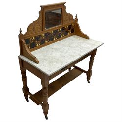 Late Victorian satin walnut washstand, raised bevelled mirror and tiled back carved with scrolled foliage, white marble rectangular top over two drawers, on collar turned supports joined by under-tier 