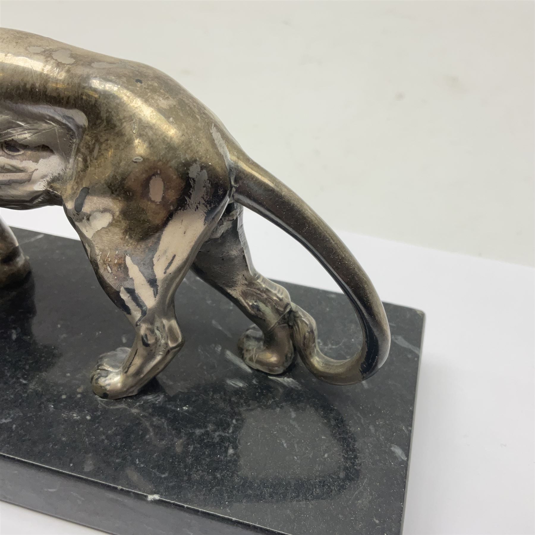 Silvered metal lion, upon a rectangular base, H12cm