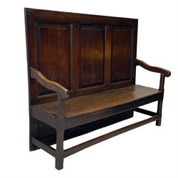 18th century oak settle, the high back with three fielded panels, shaped arms and solid plank seat, standing on square supports joined by stretchers