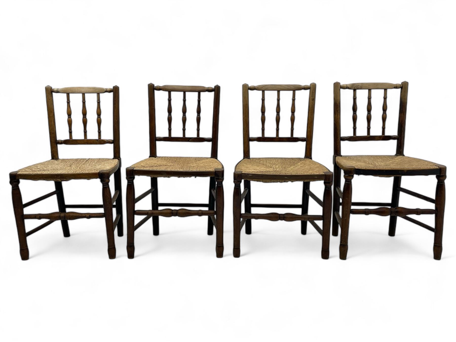 Set of four 19th century elm spindle back chairs, bar cresting rail over three turned vertical spindles, rush seat on turned supports united by turned stretchers 