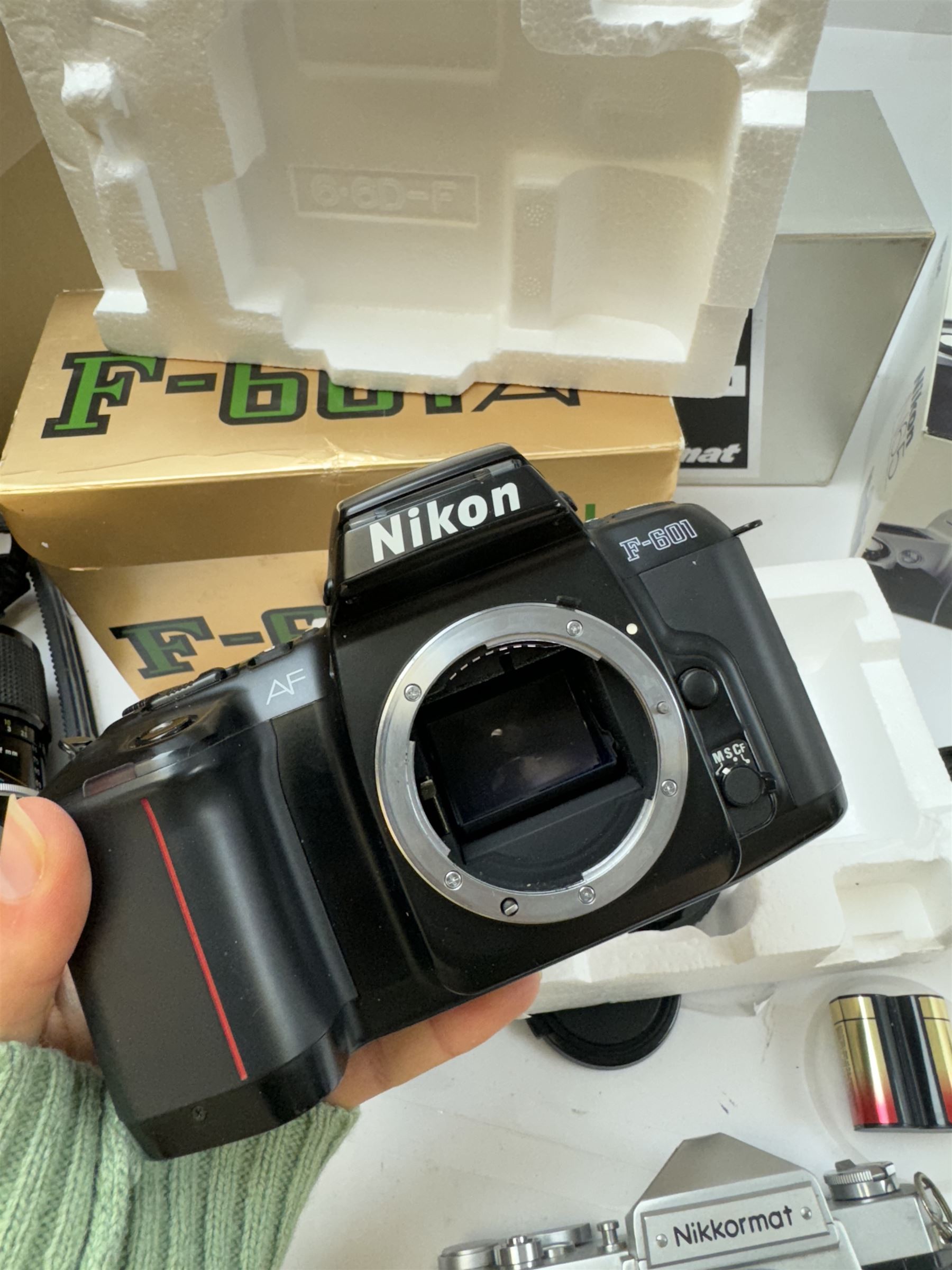 Collection of Nikon cameras, to include N65 serial no. 3103095, boxed, AF F-601 serial no. 2049522, boxed, F-801s serial no. 3330641, F-301 serial no. 3349050 and two Nikkormat cameras, to inlcude an EL example serial no. 5236494, with a nikkor Zoom 43-86mm 1:35 lens serial no. 913104, boxed and one other