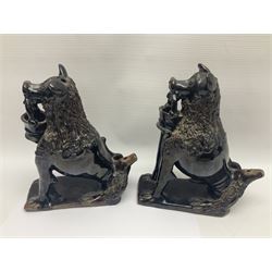 Pair of unusual early English pottery figures, modelled in the form of seated dogs with baskets between their jaws, the tails forming whistles, each upon rectangular base, overall H22cm