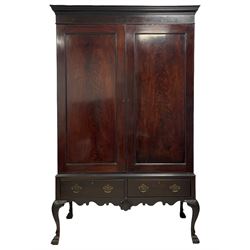 19th century Irish mahogany press wardrobe, projecting dentil cornice over two figured panelled doors, enclosing three sliding trays and hanging rail with coat hooks, fitted with two drawers to base over a shaped apron, raised on acanthus carved cabriole supports with paw feet, retailed by Millar & Beatty of Dublin, with paper labels verso, collected and restored by Michael Butler (1870-1900), impressed stamp to side and ink stamp to drawer inscribed 'M Butler collector of high-class furniture and works of art'