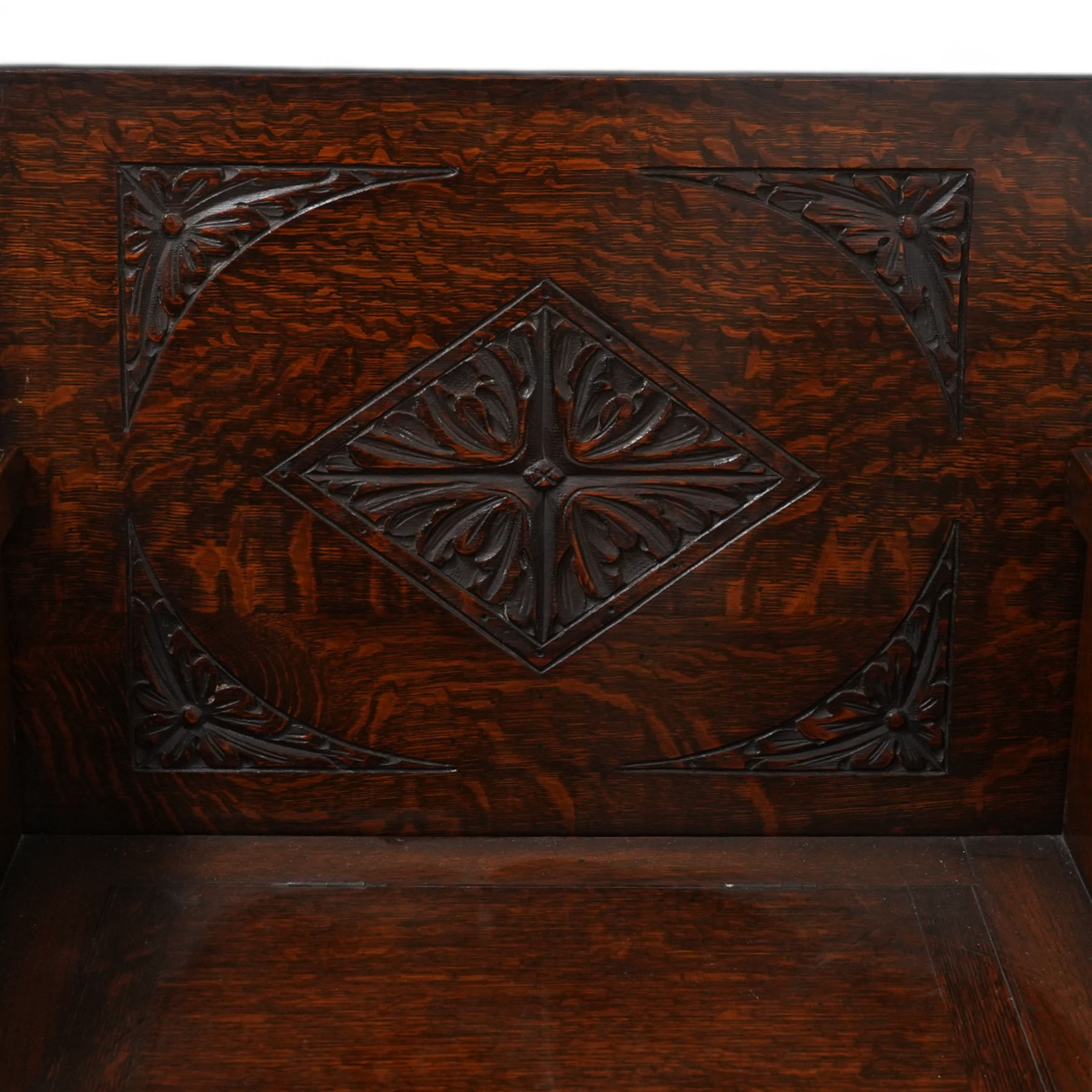 Early-to-mid-20th century carved oak monk's bench, metamorphic top with foliate lozenge carvings, over box seat with hinged lid, arcade carved lower rail on shaped feet