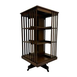 Early 20th century oak revolving bookcase, moulded square top over three tiers, with moulded vertical slats, on four spoke base with castors 