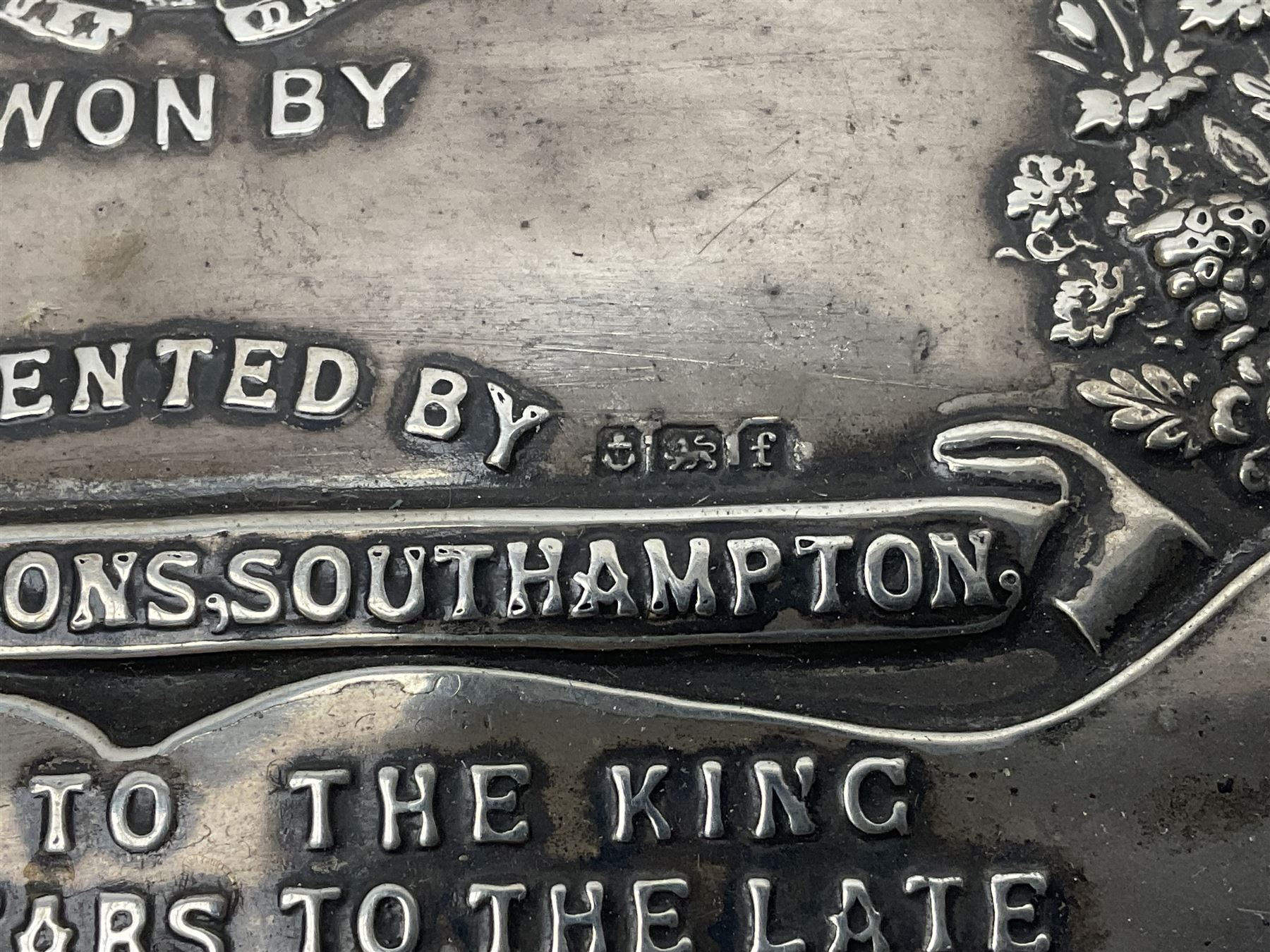 Silver presentation plaque, the Toogood Championship Shield, embossed with lion and flowers, mounted upon a velvet easel style support, hallmarked H17cm