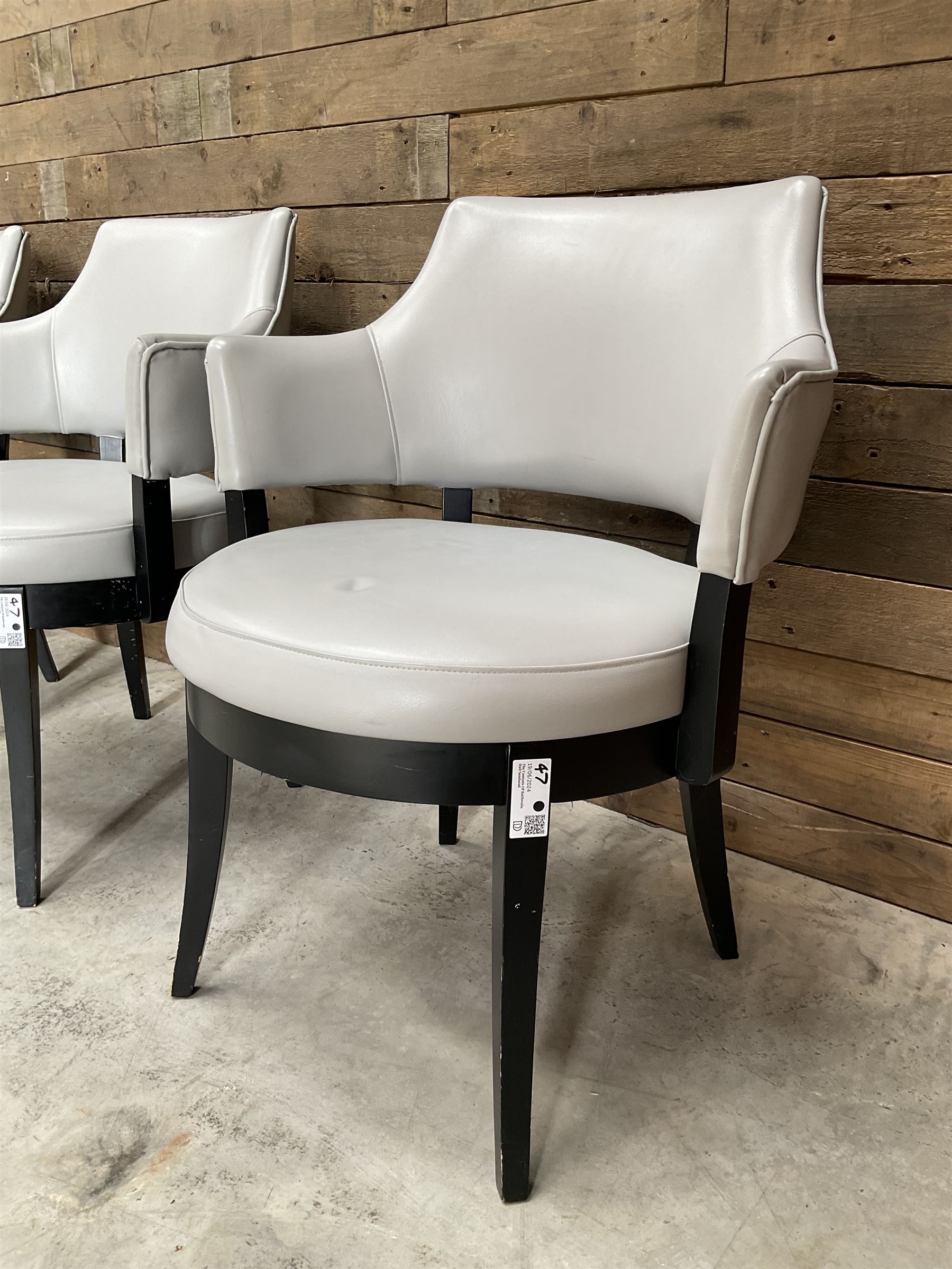 Four ebonised framed tub shaped armchairs, upholstered in grey fabric