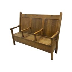 Early 20th century oak settle, featuring a high back with three panel sections and hinged lids, the bench seat divided into three sections, each with its own armrests, supported by square legs