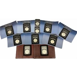 Eleven United States of America silver dollar coins from ‘The complete uncirculated American Eagle Silver Dollar Collection’, each housed in a rectangular capsule