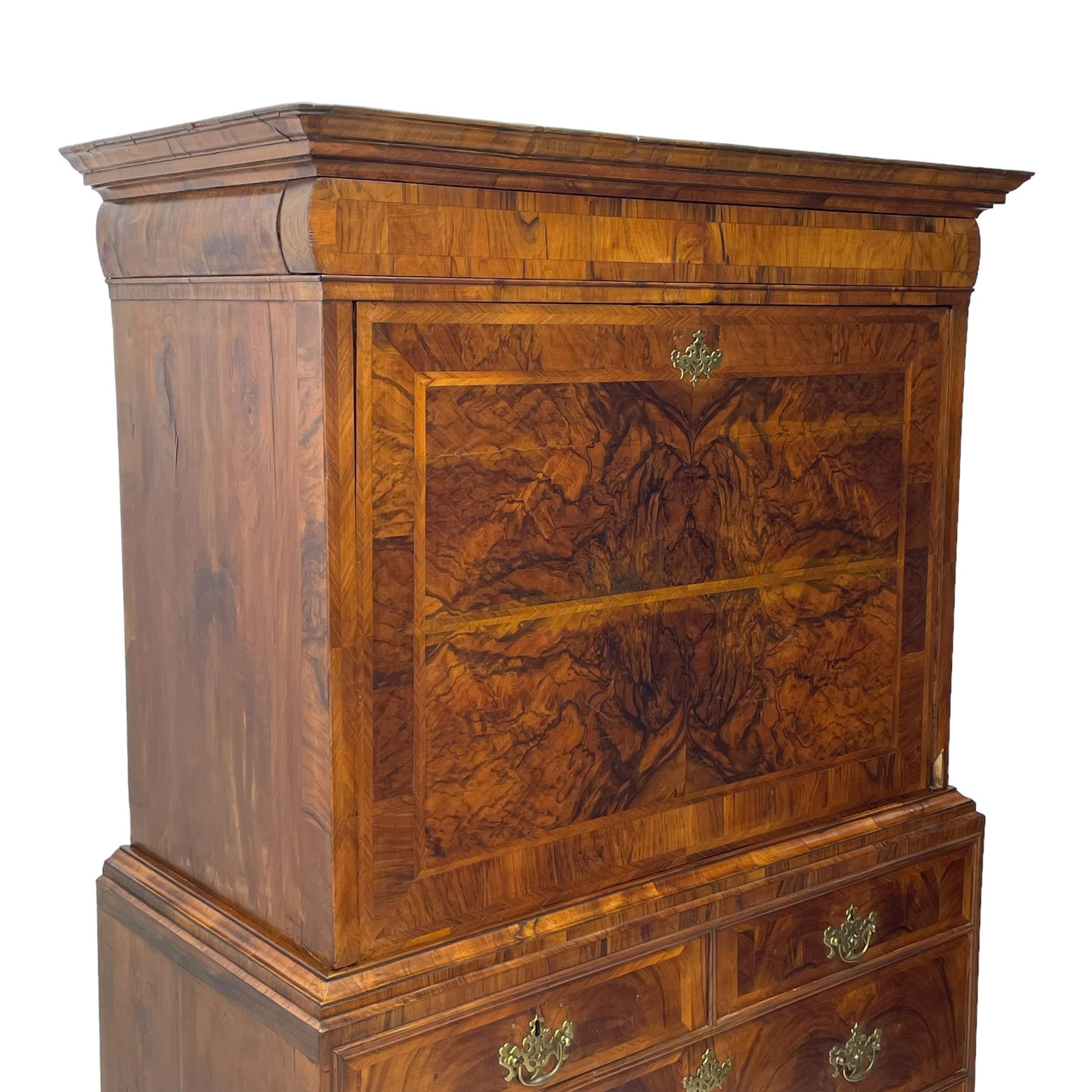 Early 18th century William & Mary figured walnut escritoire, projecting moulded cornice over shallow frieze drawer, the figured fall front enclosing interior fitted with small drawers, cupboards, pigeon holes and hidden drawers, the lower section fitted with two short and two long graduating drawers, on tall bracket feet 