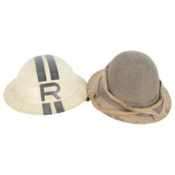 Two WWII British brodie helmets, one example painted white with a black R tot eh front and back, with neck strap  