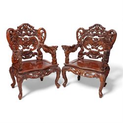 Pair of Japanese carved hardwood throne chairs, pierced and dragon carved cresting over pierced back panel carved with bat, extending dragon carved arms over panelled seat, the seat rails pierced and carved with trailing branches and foliate motifs, on cabriole supports 