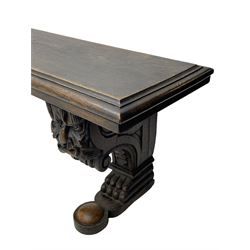 Victorian oak bench, moulded rectangular top, on mask and scroll carved corbel supports with paw feet, rectangular platforms with rounded terminals and applied roundel 