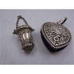 Edwardian silver pin cushion, in the form of a heart, with embossed floral decoration, with blue pin cushion between two heart shaped silver covers, with chatelain hook, hallmarked Henry Matthews, Birmingham 1902, together with a late Victorian silver thimble holder, embossed with scrolling decoration and with velvet interior, with chatelain chain, hallmarked Levi & Salaman, Birmingham 1899, pin cushion H4.5cm