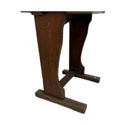 Three pitch pine school desks, each with rectangular lift-top with recessed ink well enclosing storage compartment, on trestle supports joined by stretcher