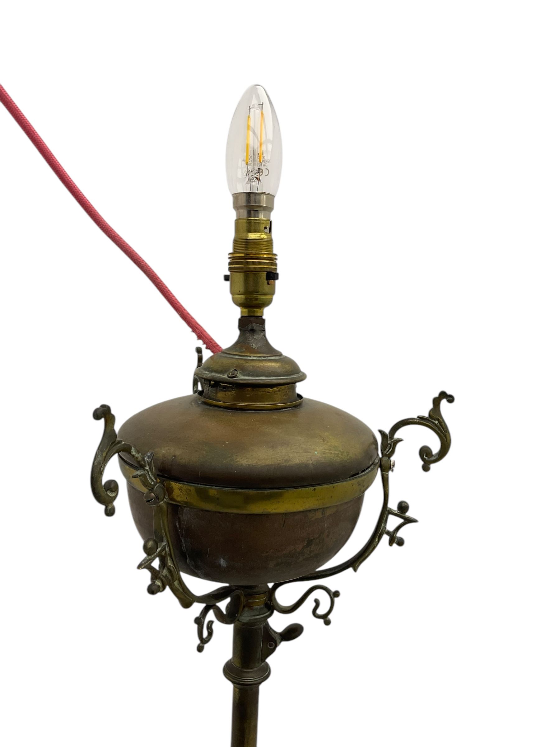 Victorian brass converted oil lamp stand, telescopic stem with scrolled uprights terminating to scrolled feet, dished base decorated with scrolling cast metal work and grotesque masks 