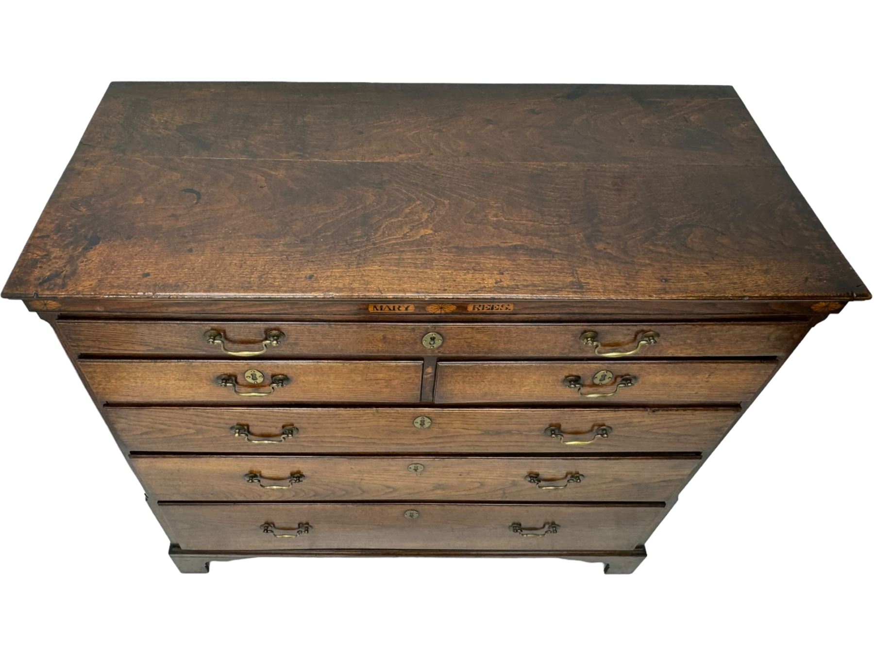 George III oak chest, rectangular top over frieze with inlaid with inscription panels 'Mary Rees' and fan motifs, frieze drawer over two short and three long graduating drawers, fitted with brass swan-neck handles and oval escutcheons, on bracket feet