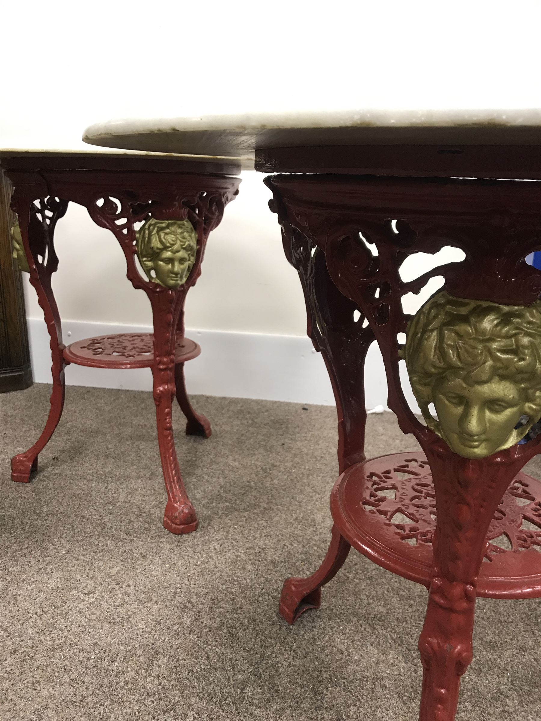 Pair cast iron Britannia pub tables, two red, small marble tops 