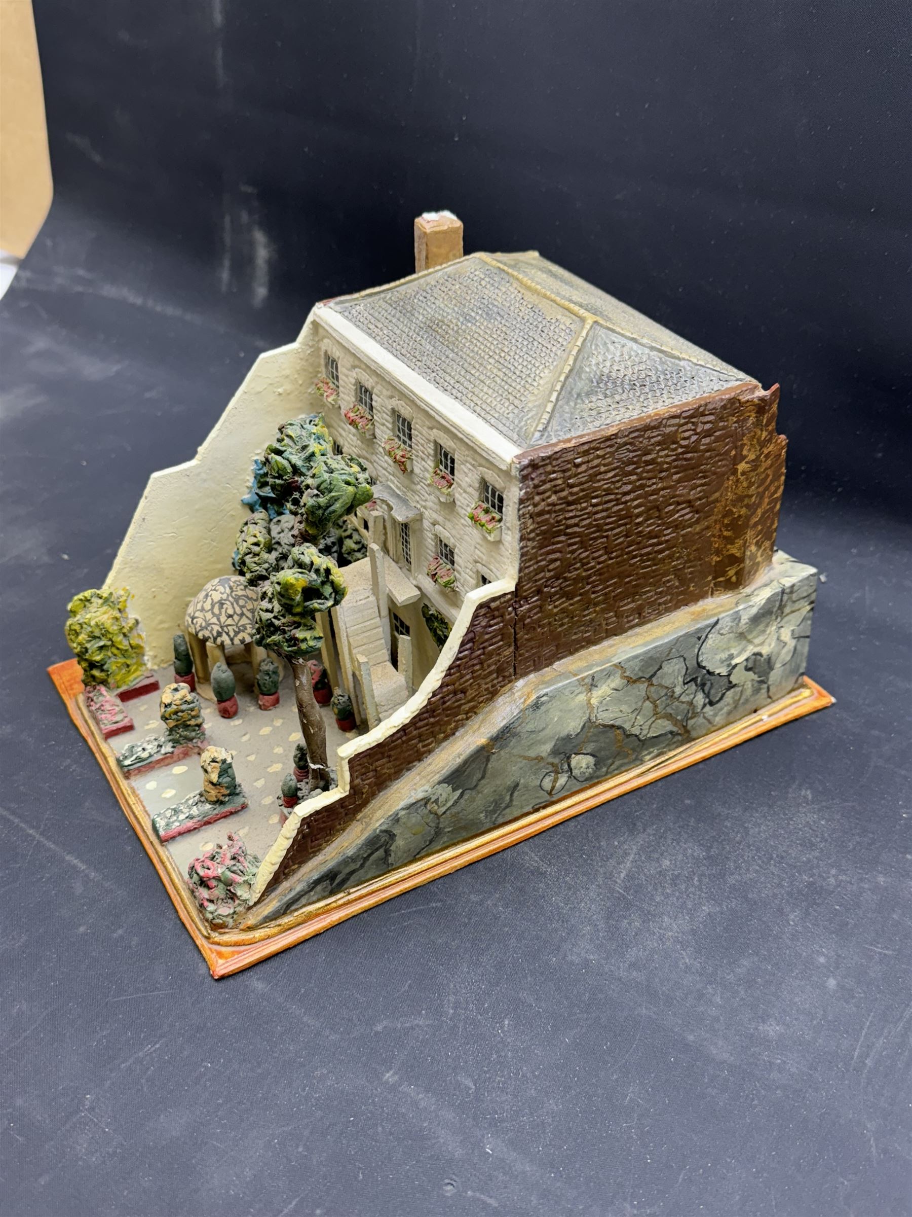 Mixed medium sculpture of house and garden, with makers mark beneath, H15cm