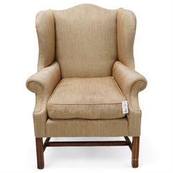 Georgian design wingback armchair, upholstered in brown herringbone fabric, on square moulded supports united by plain H-stretchers