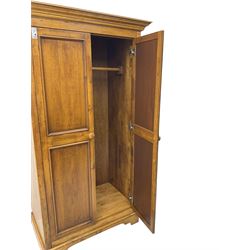 Hardwood double wardrobe, enclosed by two panelled doors, on bracket feet 