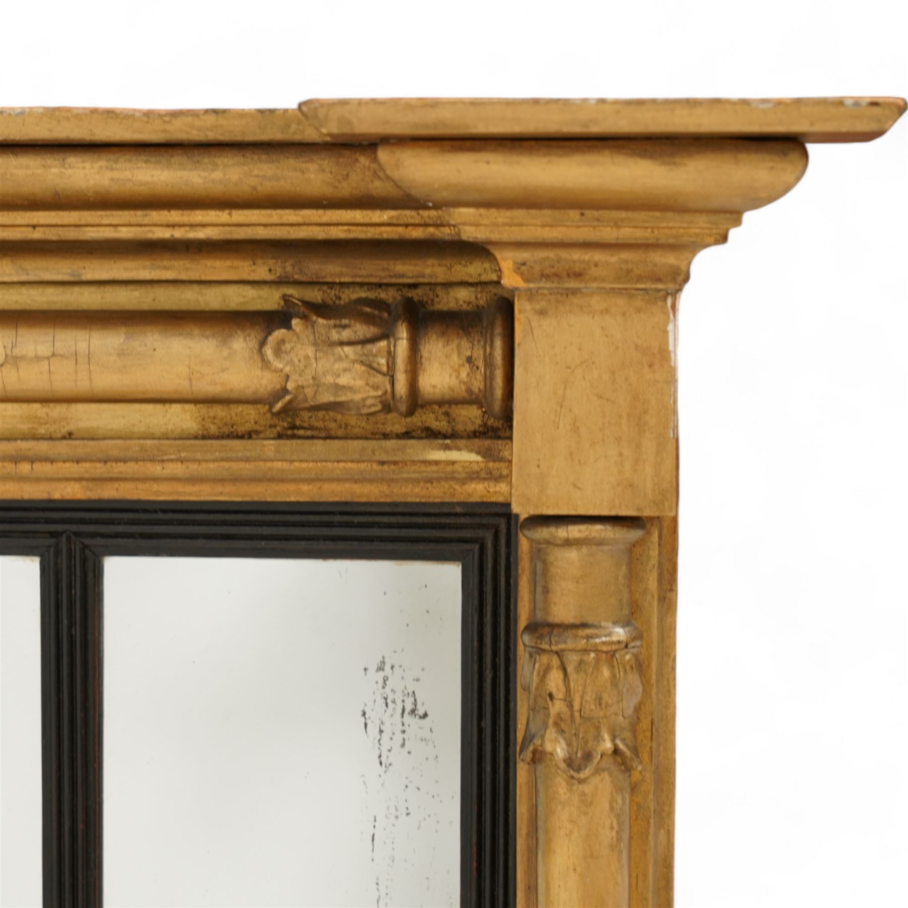 Regency gilt wood overmantel mirror, moulded cornice with projecting square ends, fitted with three turned column mounts with foliage decoration, ebonised and reed moulded slip dividing the mirror into three sections, moulded lower rail, plain mirror plates