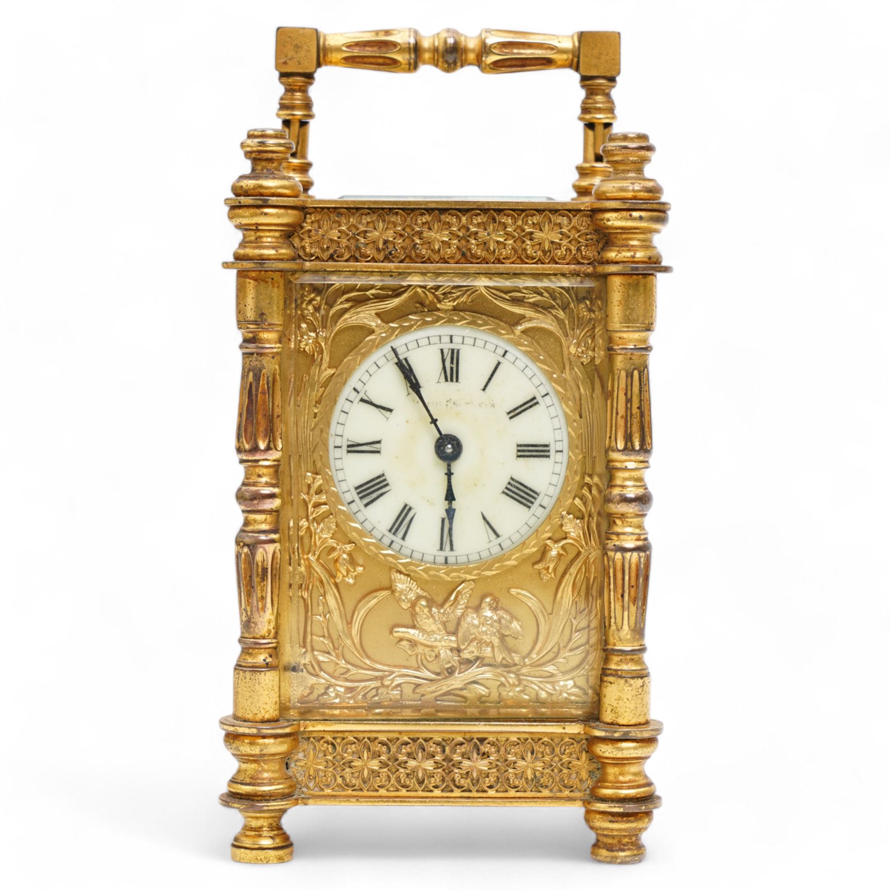 French - Edwardian 8-day timepiece carriage clock in a brass case with glazed side and rear door panels, brass foliate embellished dial mask with a circular enamel dial, Roman numerals and retailers name (indistinct), minute track and steel hands, with a cylinder platform escapement, wound and set from the rear.  