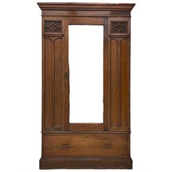 Edwardian walnut wardrobe, projecting moulded cornice over bevelled mirror glazed door, panelled uprights with upper glass panels behind fretwork, the base fitted with single drawer 