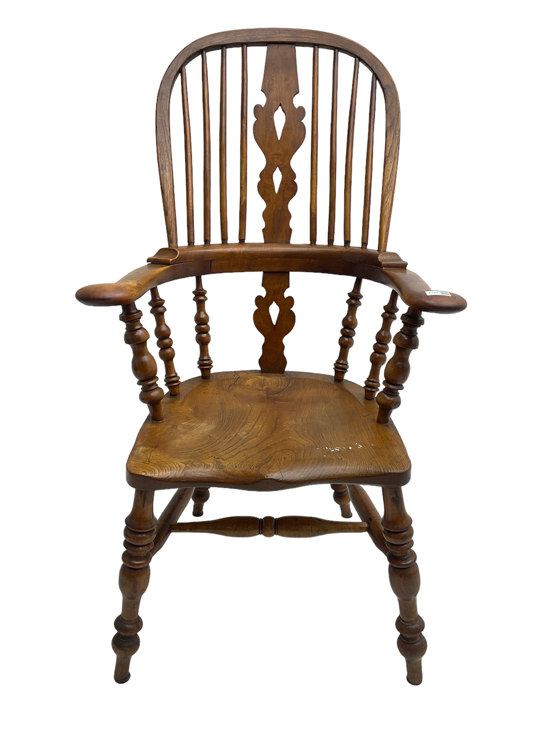 Elm and beech high back Windsor chair,  high hoop back with pierced splat and spindle supports over shaped saddle seat, raised on ring turned supports united by H-stretcher