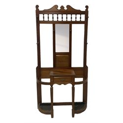 Late Victorian hallstand, raised pediment over balustrade frieze, bevelled mirror back with coat hooks over glove drawer, fitted with two drip-trays to base