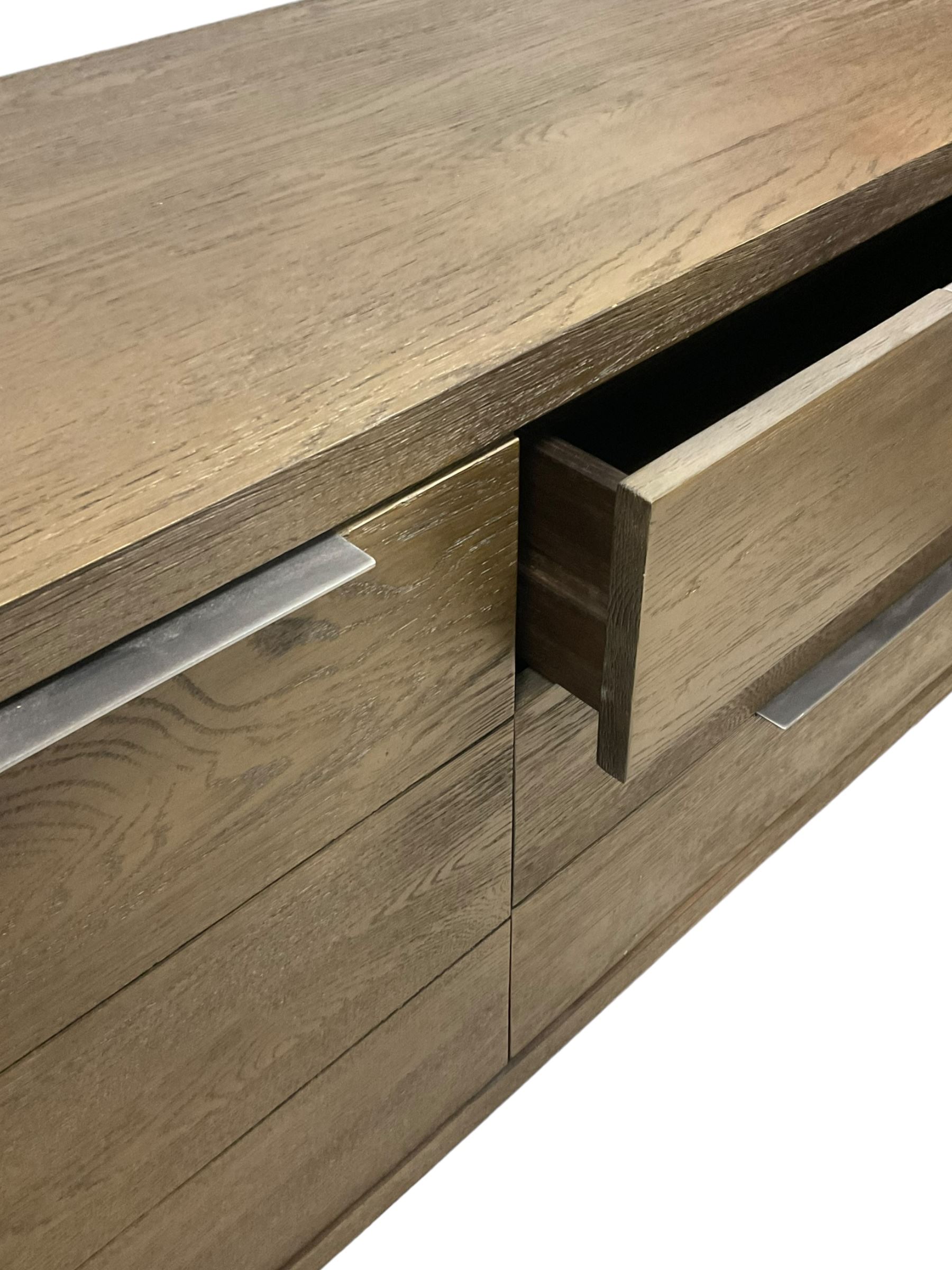 Contemporary dark oak finish sideboard, three central drawers flanked by single cupboards, on angular black finish metal supports 