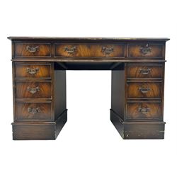 20th century mahogany twin pedestal desk, moulded rectangular top with red leather inset with gilt tooled border, central drawer over kneehole flanked by two banks of four graduating cockbeaded drawers, on plinth base