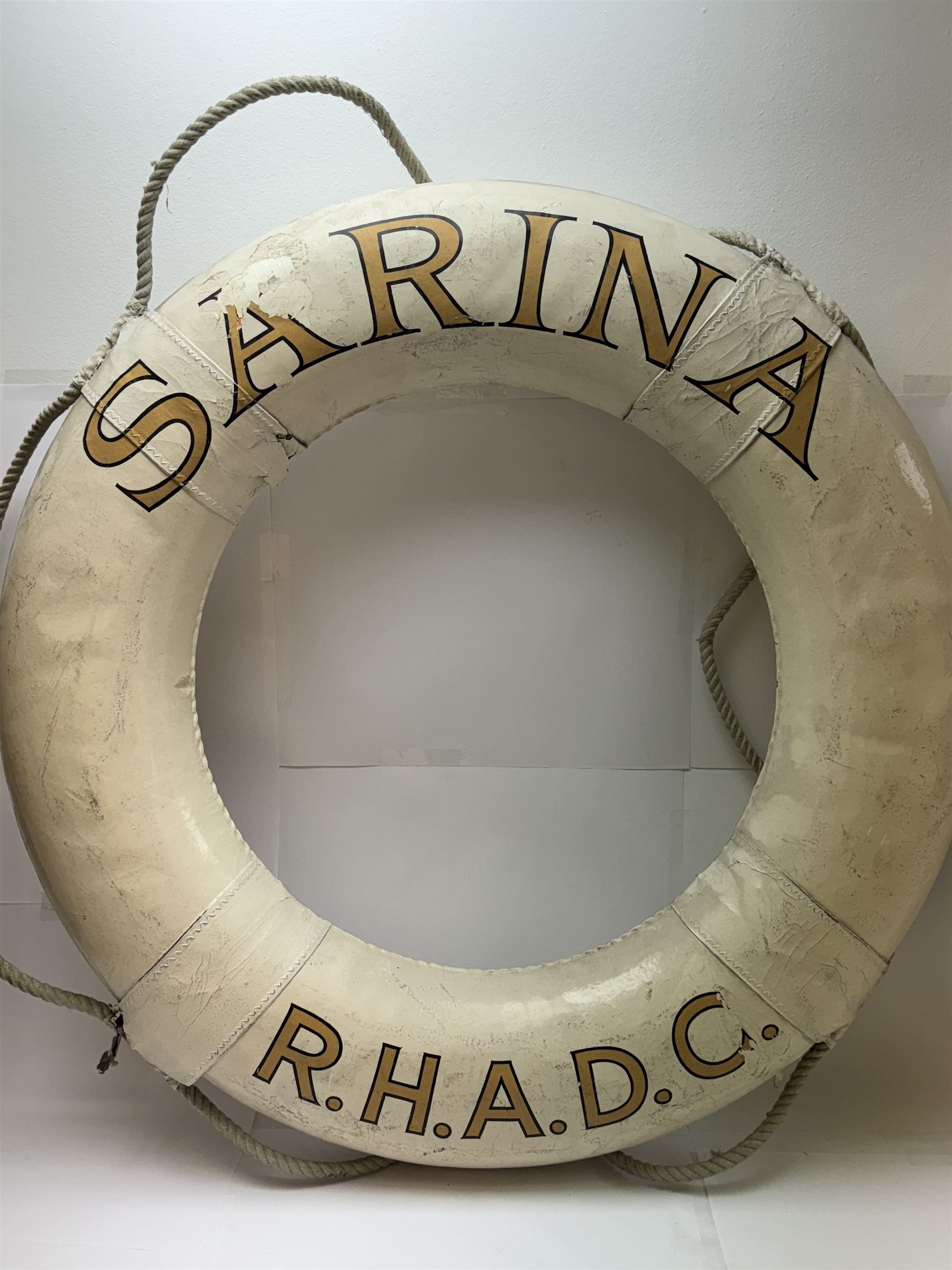 Four mid 20th century yacht lifebuoys, each painted in gold and black lettering 'Sarina R.H.A.D.C', upon a white ground, D68cm