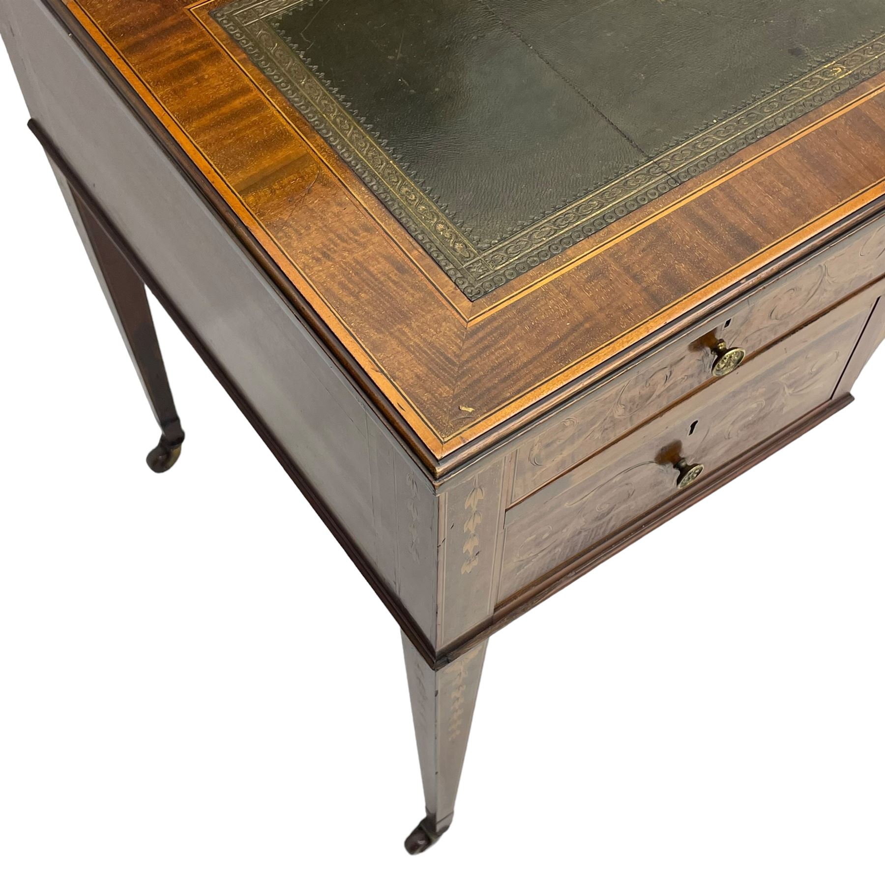 Edwardian inlaid mahogany writing desk, raised galleried back over inlaid central urn with scrolling leafy branches and six small drawers, satinwood banded rectangular moulded top with tooled leather inset, fitted with five drawers, the drawer facias inlaid with scrolling foliage and satinwood banding, square tapering supports inlaid with trailing bell flowers, on brass and ceramic castors 