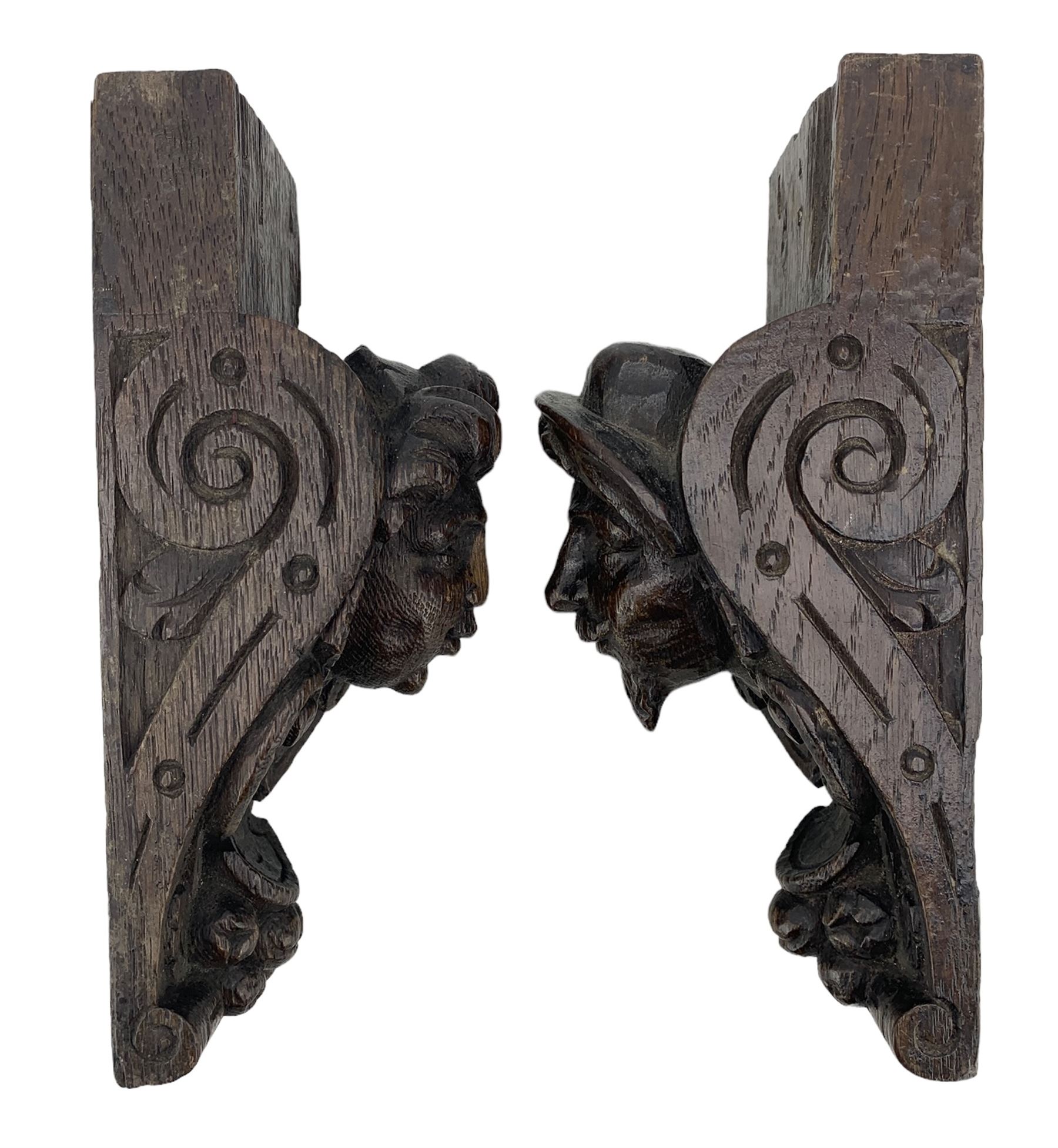 Pair of Victorian figural carved oak corbels, modelled as male and female masks, with scroll and fruit details, H22cm x W8.5cm 