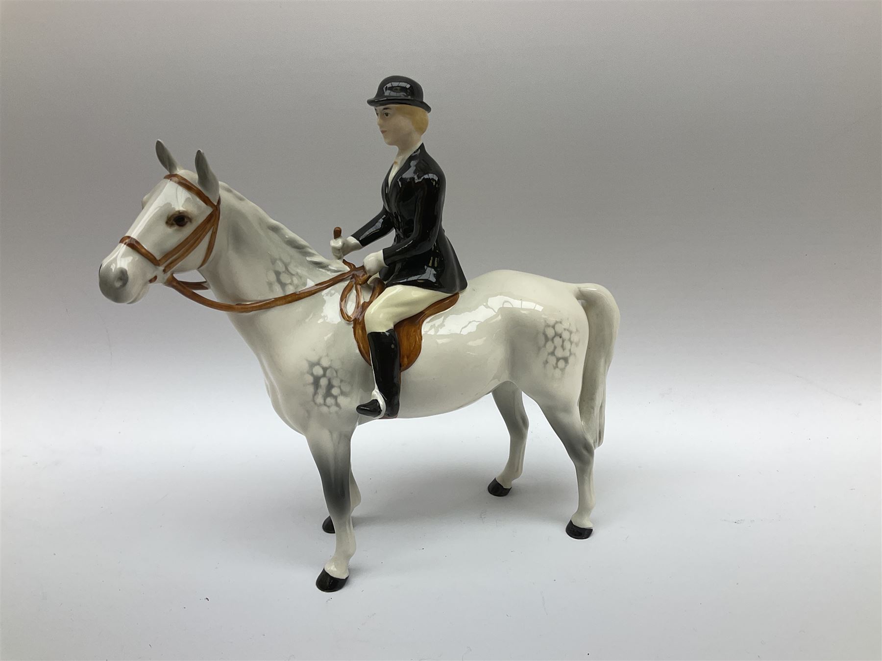 Beswick Hunting Group, comprising: two huntswoman on grey horses, model no 1730, huntsman on a bay horse, model no 1501, a seated fox, model no 1748, eighteen fox hounds and a spaniel, model no 967, all with printed marks beneath, together with three other ceramic huntsman on horseback and two hounds. 