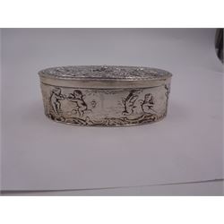 Late 19th century German Hanau silver box, of oval form, embossed throughout with putti in various scenes including riding a dog, playing instruments, pulling a cart and dancing, opening to reveal a gilt interior, with Hanau marks for B Neresheimer & Sohne, W9cm, H3cm