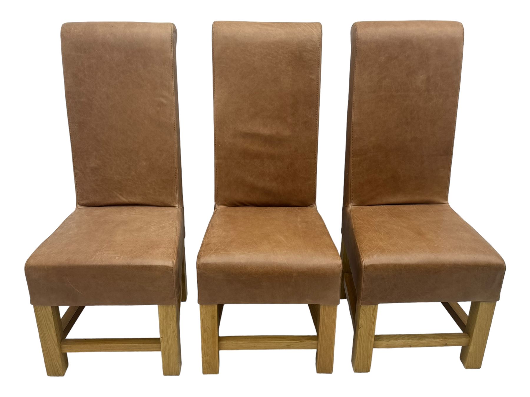 Set of six contemporary light oak dining chairs, each with high back and seat upholstered in pale tan leather, on square supports connected by H-stretcher