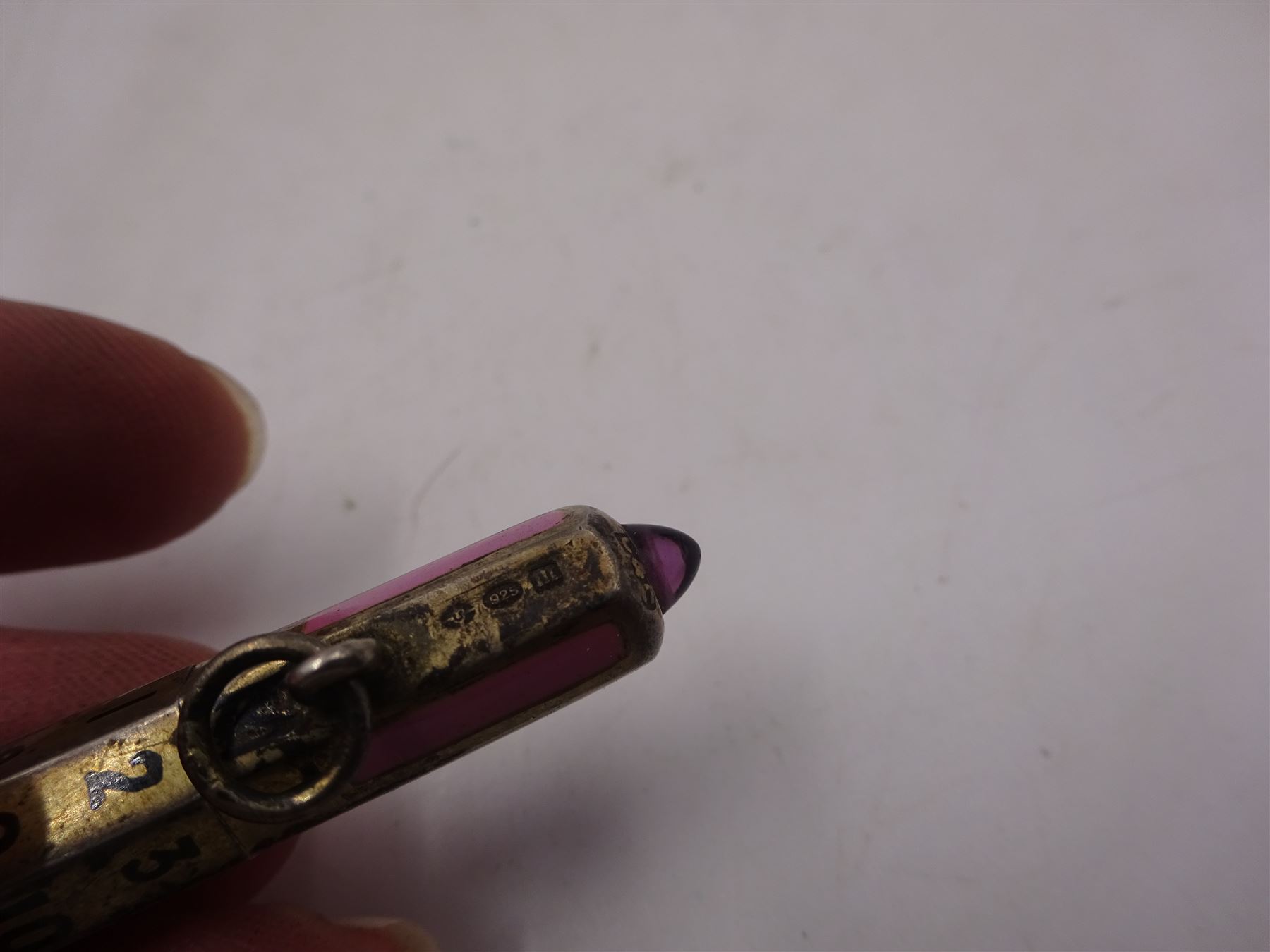 1920s silver and enamel calendar pencil, the silver faceted body decorated with panels of pink enamel with central adjustable calendar to centre, set with purple polished stone to one end, with London import marks for 1927, Cohen & Charles, L6.5cm