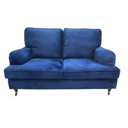 Howard design - two-seat sofa upholstered in blue fabric, traditional shape with rolled arms, on walnut finish turned feet with brushed metal cups and castors