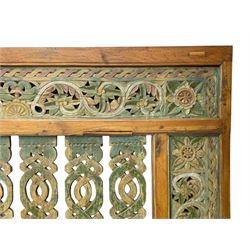 Early 20th century Javanese teak and hardwood door panel or room divider, rectangular panelled form with moulded frame and pegged construction, carved and pierced with scrolling decoration and flower head motifs, shaped and pierced splats with interlocking pattern