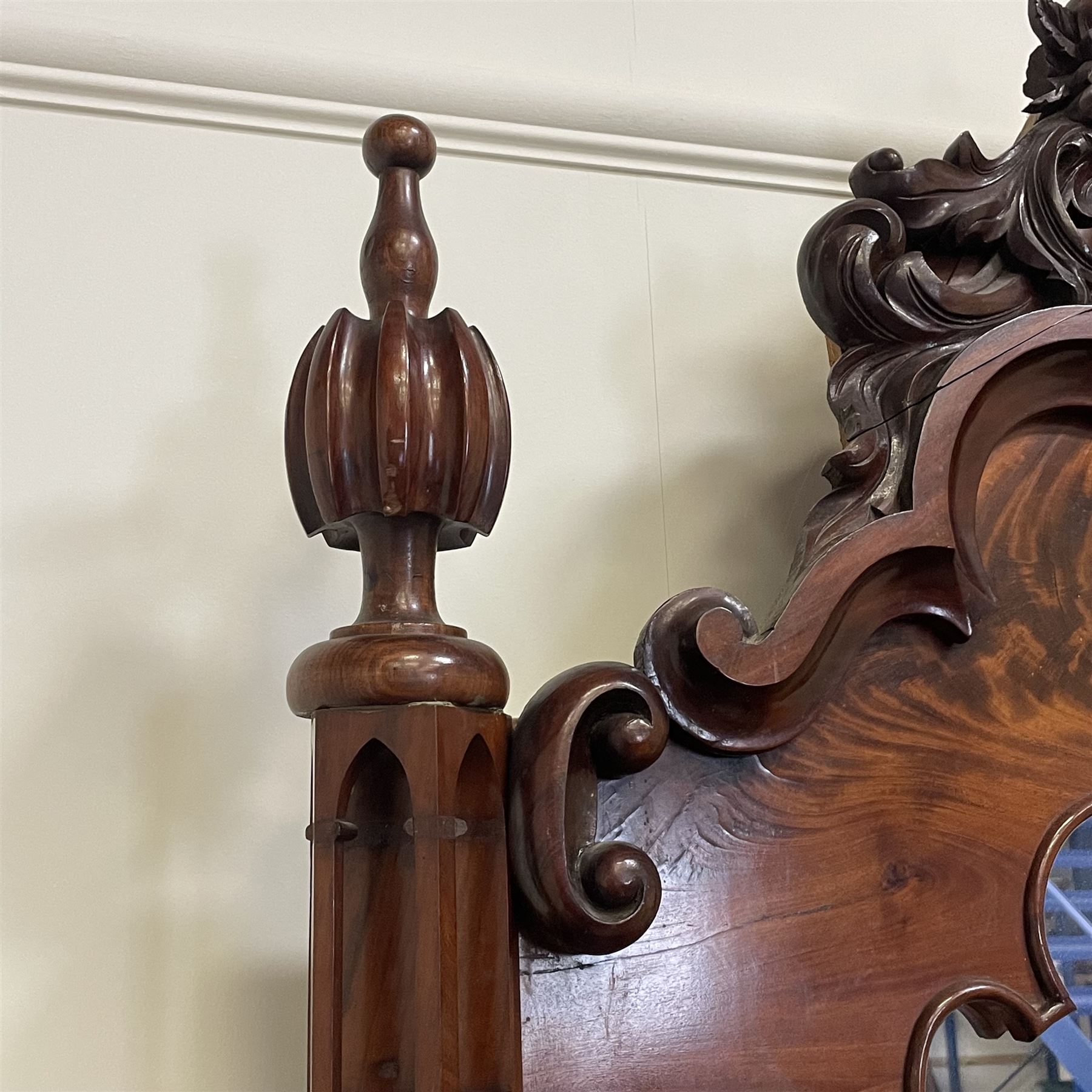 Tall Victorian figured mahogany twin pedestal dressing table, the tall mirror with flower head and scrolled leaf carved pediment, flanked by two turned and carved finials over faceted lancet arched lantern tops, plane mirror plate enclosed by shaped frame, pierced and undulating moulded uprights, on C-scroll and curled leaf carved supports fitted with cast brass hinged candle sconces, each pedestal fitted with two small trinket drawers over larger drawer and panelled cupboard, canted corners with matched upright mounts, the cupboard doors enclosing slides, on scroll carved feet 