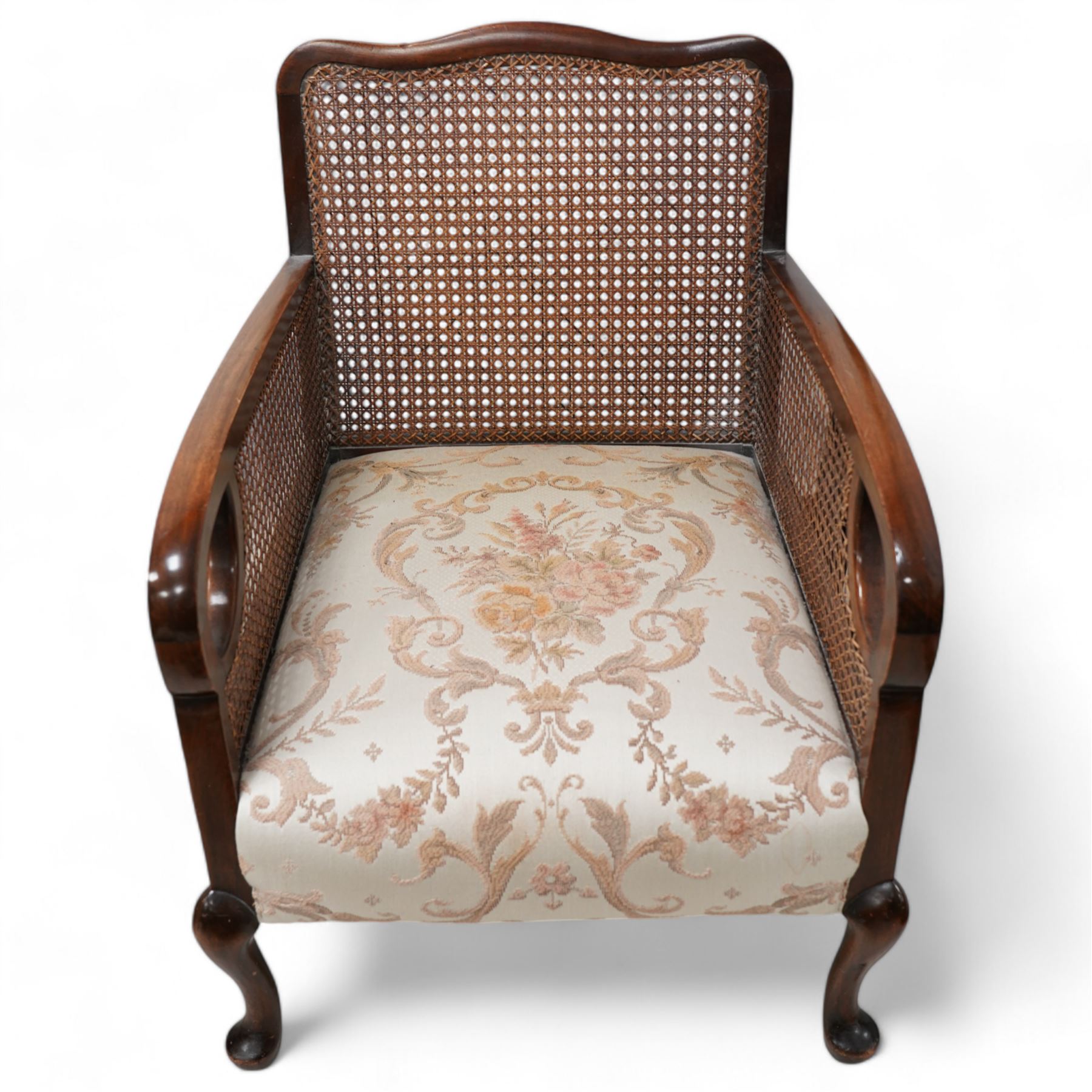 Early 20th century bergere lounge suite - two-seat sofa (W140cm, H80cm, D72cm); and pair of armchairs (W64cm); together with footstool, upholstered in floral fabric