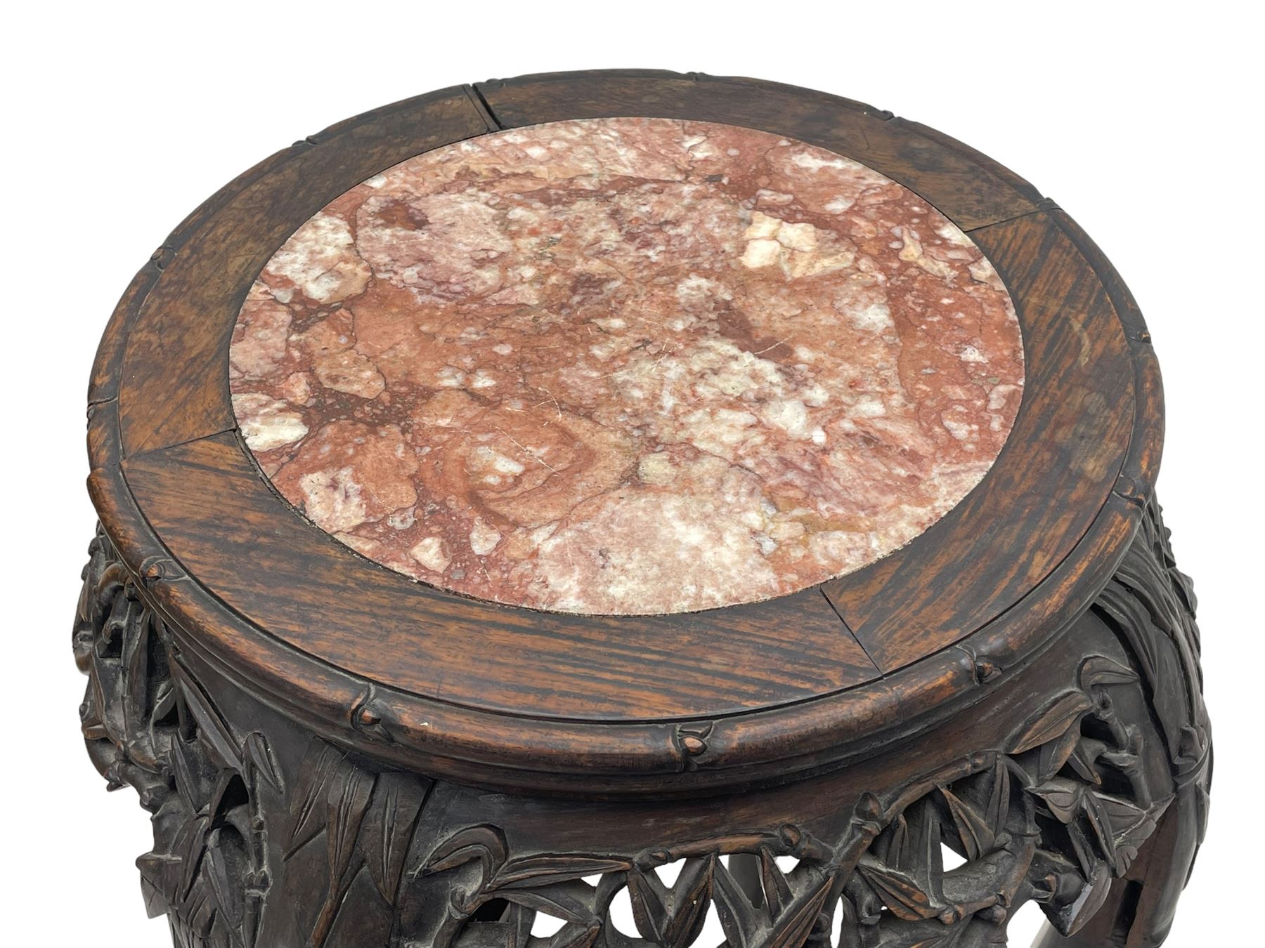 Early 20th century Chinese hardwood plant stand, circular top with marble inset, carved and pierced with interlacing foliage, on leaf carved supports united by x-framed stretchers