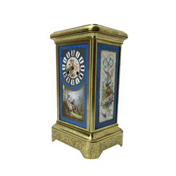 French - late 19th century 8-day mantle clock in an engraved brass corniche case with three rectangular porcelain panels decorated in the romantic Sevres style, dial with brass hands, cartouche Roman numerals and a depiction of cupid to the dial centre, rack striking movement sounding the hours and half hours on a bell. With pendulum.