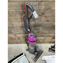 Dyson DC40 vacuum cleaner with various attachments, and a Vax cordless vacuum cleaner with single battery and charger