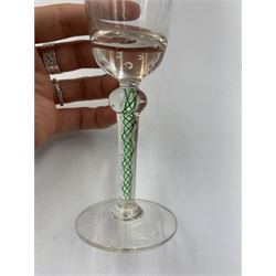 19th century continental liqueur glass, circa 1870, bucket bowl with bubble decoration, the tapered stem with green and white strands, H12.5cm; together with a Victorian aperitif glass, trumpet bowl decorated with foliate and fruiting vines, H10cm (2)