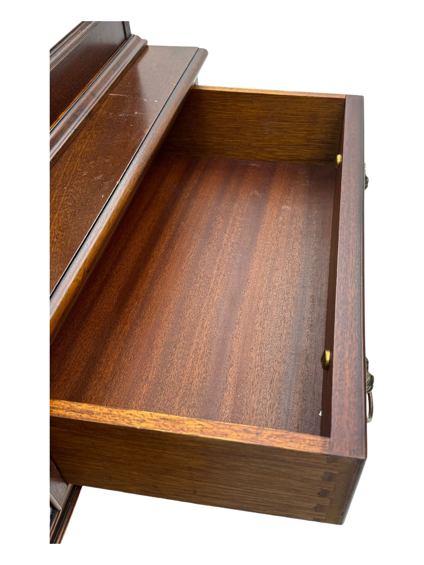 Georgian design mahogany bookcase on cupboard, projecting moulded and dentil cornice, two display cabinets enclosed by glazed doors above over three drawers and three cupboards, on bracket feet